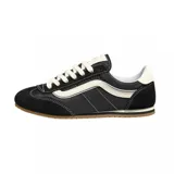 Championes Vans modelo Super Lowpro, de diseño urbano y perfil bajo. Presentan una combinación de gamuza negra en puntera y talón con paneles laterales de lona, destacando la icónica banda lateral Sidestripe en color blanco. Incluyen cordones blancos, suela de goma color caramelo y detalles de costuras visibles.