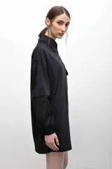 Remerón negro con cuello camisero, mangas largas con puños elásticos y bolsillo con solapa en el pecho.