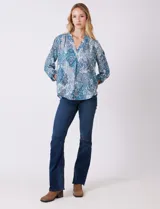 Blusa de gasa con estampado geométrico y paisley en tonos fucsia y blanco. Presenta cuello mao con escote en V, mangas tres cuartos con presilla y botón para regular el largo.