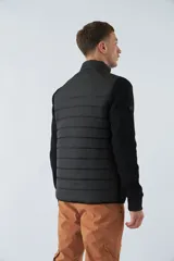 Campera azul marino con frente acolchado y mangas de felpa. Tiene cuello alto, cierre frontal, bolsillos laterales con cierre y logo de la marca en el pecho.