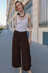 Jeans de tiro alto con diseño balloon, pernera ancha y corta, y bajo asimétrico. Cuenta con cinco bolsillos y cierre frontal con cremallera y botón.