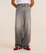 Pantalón baggy de jean azul, con bolsillos delanteros tipo cuchillo y bolsillos traseros.