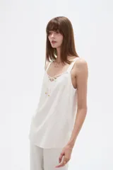 Musculosa blanca de viscosa con breteles anchos, cuello en V y detalle de lazo frontal.