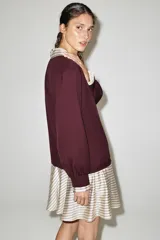 Vestido corto combinado en color bordó y crudo a rayas, con cuello solapa, cierre frontal con cremallera y mangas largas con puños.