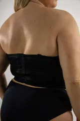 Corset corto sin tirantes de color rojo y negro, con copas armadas con aro, confeccionado en encaje con diseño floral y forrado en tul, con espalda de cintas cruzadas.