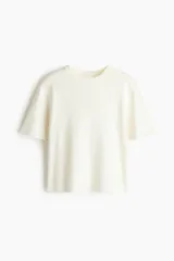 Remera de punto tupido color blanco crudo, con cuello redondo acanalado, mangas cortas con hombros caídos y bajo recto.