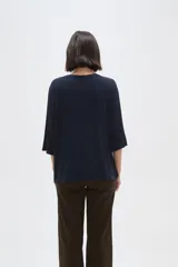 Remera de viscosa en color verde oliva, con cuello redondo y mangas 3/4. Presenta un diseño de tejido acanalado y corte holgado.