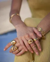 Anillo plateado con forma orgánica irregular y un agujero en el centro.