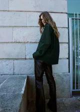 Camisa de popelín de algodón de corte oversize, color verde oscuro, con manga larga, cuello camisero y cierre frontal de botones.