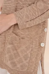 Cardigan largo marrón de tejido ligero, con diseño abierto y holgado, bolsillos frontales y botones decorativos en los costados.