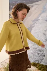 Cardigan de punto azul marino con cuello tejido a mano en crochet color crudo, cierre frontal con botones y detalles en tono borravino y crudo en los bordes y puños semióxford.