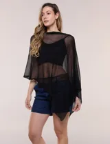 Poncho liviano de tejido de punto fino calado, color blanco, con silueta asimétrica envolvente, escote bote drapeado y mangas integradas estilo capa.