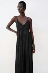 Vestido midi negro satinado con escote en pico, tirantes finos y detalle de lazada frontal. Presenta diseño de paneles fruncidos.