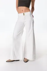 Jean blanco de tiro bajo, corte acampanado y costuras a la vista en color beige. Cierre frontal con dos botones dorados.