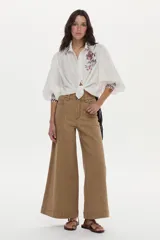 Jean wide leg de tiro alto color tostado, con diseño de perneras anchas y costuras decorativas frontales.