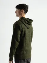 Campera negra con cuerpo capitoneado y mangas de punto gris jaspeado. Tiene capucha con cordones ajustables y cierre frontal con cremallera.