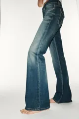 Jeans de tiro bajo y diseño bootcut, con efecto lavado, trabillas y cinco bolsillos clásicos. Cuenta con cierre frontal de cremallera y botón metálico.