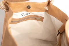 Bolso tipo tote de cuero negro con acabado brillante, diseño fruncido en los laterales y correas de hombro de tela tejida en tono beige.