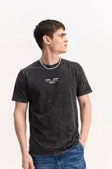 Remera de algodón color marrón con efecto gastado, de manga corta, cuello redondo y estampa tipográfica sutil al frente.