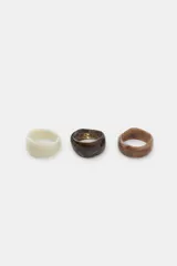 Pack de tres pulseras rígidas de resina con acabado marmolado en tonos crema, marrón oscuro y marrón claro.