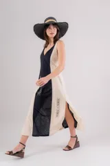 Vestido largo de lino con diseño bicolor en beige y crudo, escote en V y breteles regulables. Presenta detalles de bordados geométricos en el frente y tajos laterales.