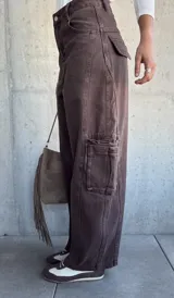 Jean de corte barrel color chocolate, con diseño cargo que incluye bolsillos laterales amplios. Presenta tiro medio y costuras reforzadas en las piernas.