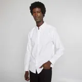 Camisa blanca de corte recto, con cuello abotonado y mangas largas.