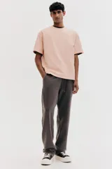 Remera color salmón de corte holgado, cuello redondo y mangas cortas.