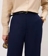 Pantalón de sastrería color bordó, de corte recto y largo midi, con cintura con pasadores y cierre frontal. Incluye un cinturón fino de poliuretano con hebilla metálica.
