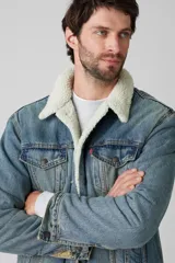 Campera de jean celeste Levi's modelo Type 3 Sherpa con cuello de corderito color crema, bolsillos frontales con solapa y cierre de botones metálicos.