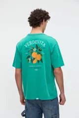 Remera de manga corta color verde, con calce relaxed y estampa en la espalda con diseño de naranjas y texto "Verdevita".