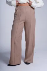 Pantalón de corte amplio y tiro alto, color beige, con elástico en la cintura trasera, pinzas frontales marcadas y bolsillos laterales.