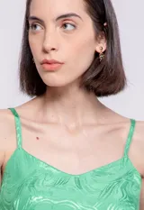 Top verde con estampado de hojas, breteles finos y escote en V.