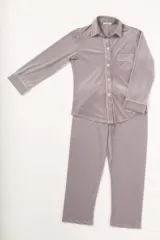Pijama gris de terciopelo con vivos rosados, compuesto por camisa de manga larga con botones y bolsillo en el pecho, y pantalón recto con elástico en la cintura.