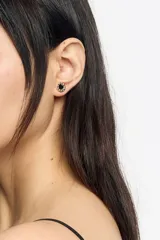 Aros tipo caravana con diseño circular, fondo negro esmaltado, corazón rojo central y borde dorado con el logo de la marca grabado.