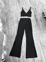 Conjunto de dos piezas compuesto por un top corto con escote en V y tirantes finos, y un pantalón de corte oxford con tiro alto, ambos en color negro con estampado de rayas verticales blancas.