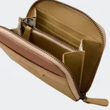 Billetera compacta con cierre de cremallera, color beige y marrón. Presenta paneles de diferentes texturas y el logo de Rip Curl grabado en el frente.