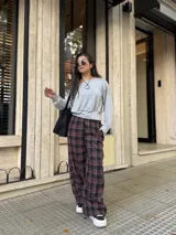 Pantalón de corte holgado tipo barrel con diseño de cuadros en tonos bordó, negro y blanco. Confeccionado en tela viyela, cuenta con cintura elástica y puños ajustados en los tobillos.