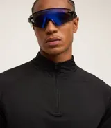 Remera deportiva térmica de manga larga color negro, con cuello alto y cremallera frontal. Presenta sisas raglán y recortes, sin estampado.