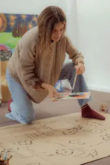 Buzo tejido en hilo de algodón color tostado, de corte holgado, con hombros caídos y diseño de ochos en la parte delantera.