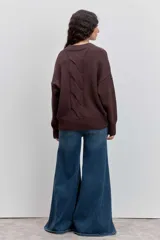 Sweater de punto en color beige, con cuello redondo acanalado, mangas largas con puños ajustados y diseño holgado.