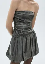 Vestido corto de fiesta con acabado metalizado brillante. Presenta un diseño palabra de honor con cuerpo drapeado y falda estilo globo con volumen. Cuenta con cierre de cremallera en la parte posterior y forro interior.