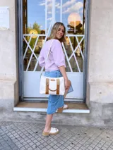 Bolso tipo tote de lona color crudo con detalles en cuero color marrón. Tiene doble asa corta de mano y correa larga de hombro.