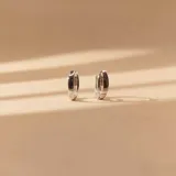 Aros tipo argolla pequeña en plata 925 con acabado satinado y detalle de tres pequeñas circonias incrustadas en el frente.