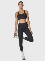 Calza negra de tiro alto con largo hasta el tobillo, confeccionada con una mezcla de poliéster y spandex, y tratada con aloe vera para mayor suavidad.