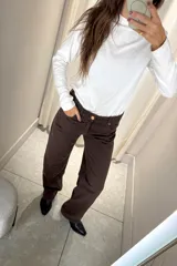 Pantalón de jean corte wide leg color marrón oscuro, con tiro medio y cierre frontal con botón metálico.