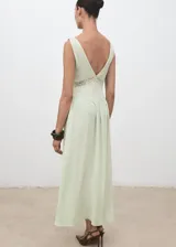 Vestido largo color verde menta, con escote en pico, tirantes anchos y diseño evasé. Presenta detalles de encaje en la zona del torso y cierre de cremallera en la parte posterior.