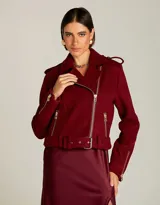 Chaqueta estilo biker de lana color bordó, con solapas amplias, cierre frontal cruzado y cremalleras metálicas doradas. Presenta hombros estructurados, cinturón ajustable en la cintura y forro interno.