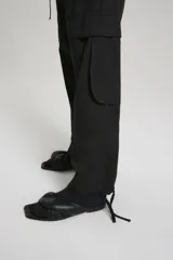 Pantalón tipo babucha de gabardina liviana color negro, con cintura elástica en espalda y tira regulable en delantero. Bolsillos en diagonal con bolsa pespunteada en delantero, bolsillos 3D plaqué en pierna delantera con tapa, tira regulable en botamanga y bolsillos plaqué con tapa en trasero.