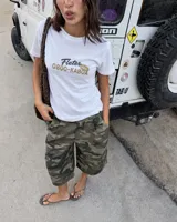 Remera blanca de manga corta, corte regular, con estampa en la espalda de un camión de fletes transportando plantas.